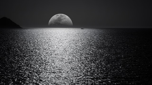 Mitad de la luna dentro del oceano de noche